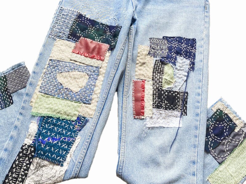 A pair of jeans, decorated with visible mending techniques